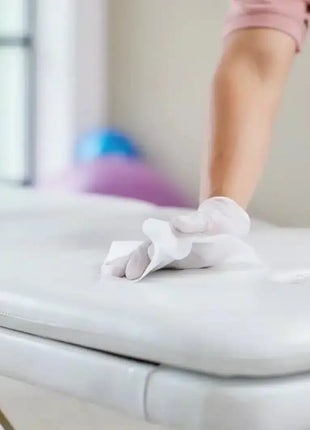 Desinfektion einer Behandlungsliege mit Einwegtuch, professionelle Hygiene, Reinigung