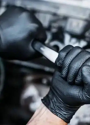 Bild vom GoGrip Nitrilhandschuh in schwarz bei der Arbeit an einem Auto
