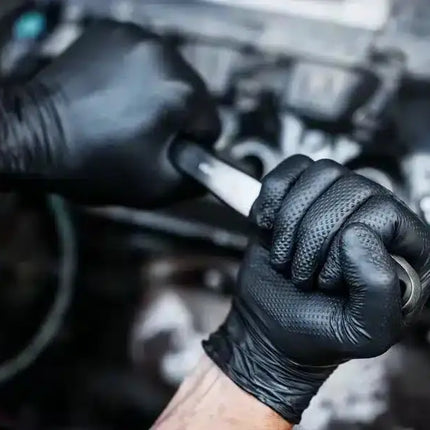 Bild vom GoGrip Nitrilhandschuh in schwarz bei der Arbeit an einem Auto