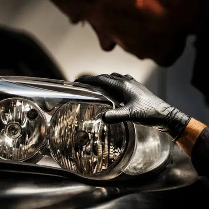 Anwendungsbild von Mercator Medical GoGrip schwarz von einem KFZ Mechaniker der einen Scheinwerfer hält