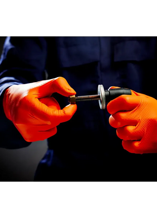 Handwerk mit orangefarbene Einweghandschuhe, Drehen einer Mutter auf eine Schraube, Arbeitsschutz