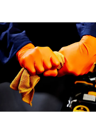 Orange Einweghandschuhe schützen Hände bei Reinigung mit gelbem Tuch, ideal für Hygiene