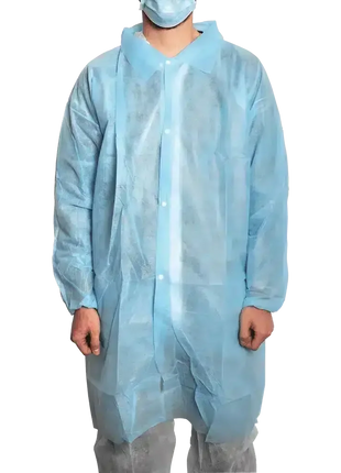 Person mit blauer Einweg-Schutzkittel und Mundschutz für Hygiene und medizinische Sicherheit
