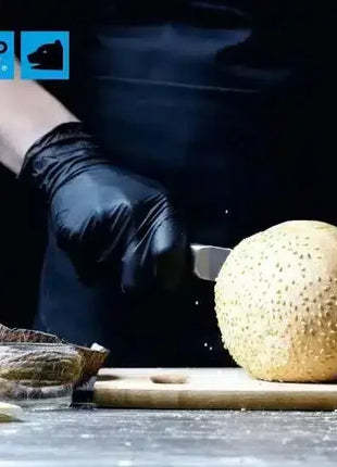 Hygiene Einweghandschuhe schwarz beim professionellen Schneiden einer Melone in Küche