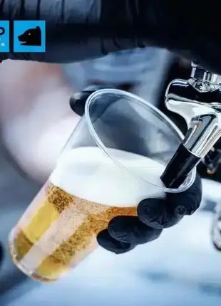 Hand mit schwarzem Einweghandschuh zapft Bier in Einwegbecher an Zapfanlage, Hygiene Produkt