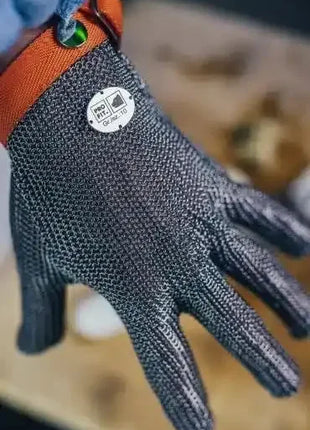 Hand mit Edelstahl-Fleischerschutzhandschuh, Schnittschutz, Arbeitsschutz, orange Bündchen