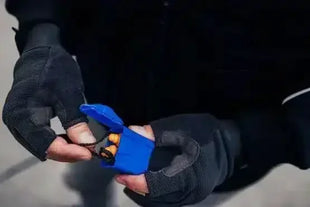 Hände mit schwarzen Handschuhen öffnen eine blaue Box mit Ohrstöpseln für Gehörschutz