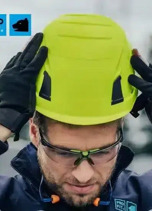 Arbeiter mit gelbem Schutzhelm, Schutzbrille und Handschuhen für Arbeitssicherheit