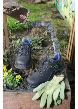 Sicherheitsschuhe und grüne Gartenhandschuhe in Hochbeet, Frühling, Arbeitsschutz