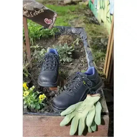 Sicherheitsschuhe und grüne Gartenhandschuhe in Hochbeet, Frühling, Arbeitsschutz