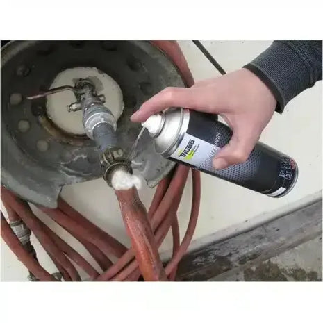 Lecksuchspray zur sicheren Lecksuche an Rohrleitungen, Hand hält Sprühdose an Ventil