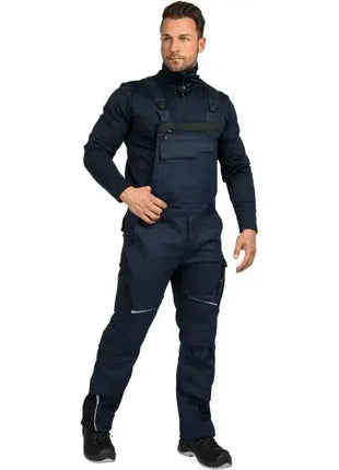 Mann in schwarzer Arbeitshose mit Latz und Funktionsjacke, professionelle Arbeitskleidung