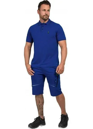 Mann in blauer Arbeitskleidung, Polohemd und Shorts, schwarze Arbeitsschuhe, Studioaufnahme