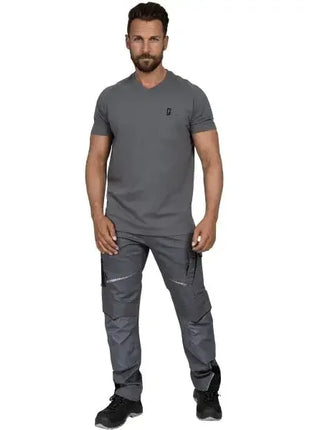 Mann in moderner grauer Arbeitskleidung mit T-Shirt und Cargohose, stehend, auf weißem Hintergrund