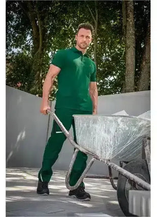 Mann in grüner Arbeitskleidung mit Schubkarre, Arbeitskleidung für Bau und Handwerk