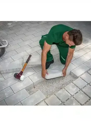 Handwerker verlegt rechteckige Gehwegplatten auf Pflastersteinen, Gartenbau, Pflasterarbeiten