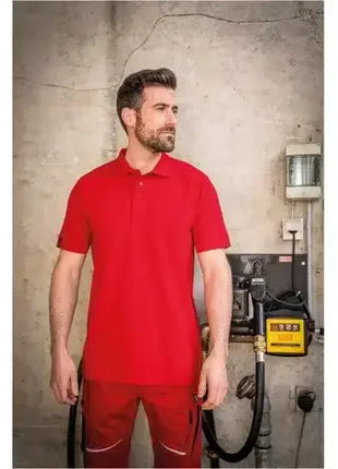 Mann im roten Poloshirt und Arbeitshose vor Industrieumgebung, Arbeitskleidung, Berufsbekleidung