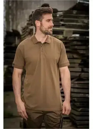Mann trägt braunes Poloshirt für Arbeitsschutz, Outdoor oder Beruf, steht im Industrieumfeld.