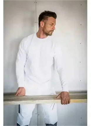 Handwerker in weißer Arbeitskleidung hält Holzbrett, professionelle Schutzbekleidung