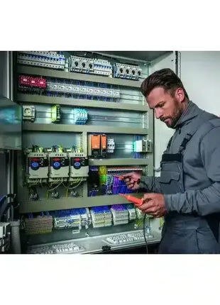 Elektriker prüft Schaltschrank mit Messgerät, professionelle Wartung und Sicherheitstechnik