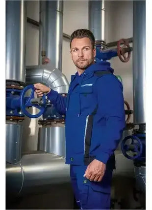 Mann in blauer Arbeitskleidung bedient Ventil an Industrie-Rohrleitung, sichere Hygiene Arbeitsumgebung