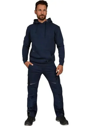 Mann in dunkelblauem Hoodie und Arbeitshose, modische Arbeitsbekleidung, Stehpose