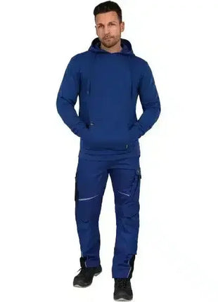Mann in blauer Arbeitskleidung mit Kapuzenpullover und Taschen, stehend, Hygiene- oder Medizinbereich