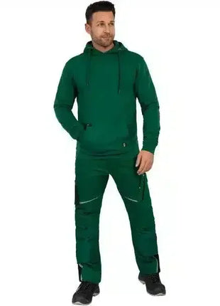Mann in grüner Arbeitskleidung mit Kapuzenpullover und Hose, stehend, professionelle Schutzbekleidung