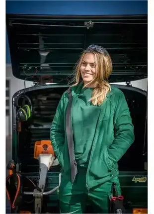 Frau in grüner Arbeitskleidung vor Transportfahrzeug, professionelle Hygiene-Ausrüstung