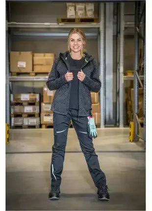 Frau in moderner Arbeitskleidung mit Handschuhen im Lager, professionelle Hygiene und Schutz