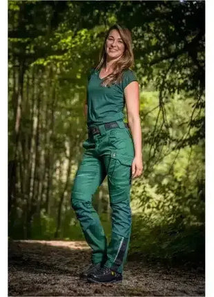 Frau in grüner Arbeitskleidung steht im Wald, robust, geeignet für Outdoor und Forstarbeit