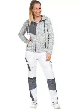 Frau in moderner Arbeitskleidung, weiß-graue Softshelljacke mit Kapuze und funktioneller Hose