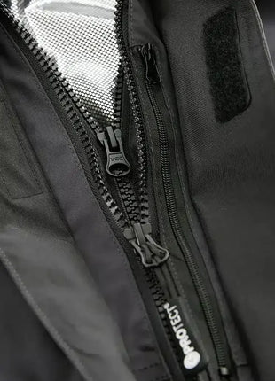 Detailansicht eines schwarzen Reißverschlusses an Schutzkleidung, atmungsaktives Material
