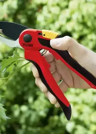 Hand hält rote Gartenschere, schneidet frischen Zweig im Grünen, robuste Klinge