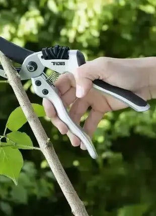 Hand hält Astschere und schneidet Zweig, Gartenschere für präzisen Pflanzenschnitt