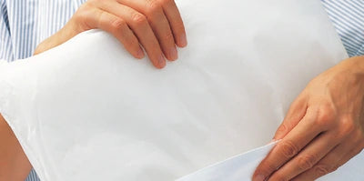 Hände halten weiße Inkontinenzunterlage für Pflege und Homecare