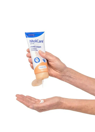 Hand trägt MoliCare Handcreme mit pflegender Formel für trockene Haut auf, medizinische Hautpflege
