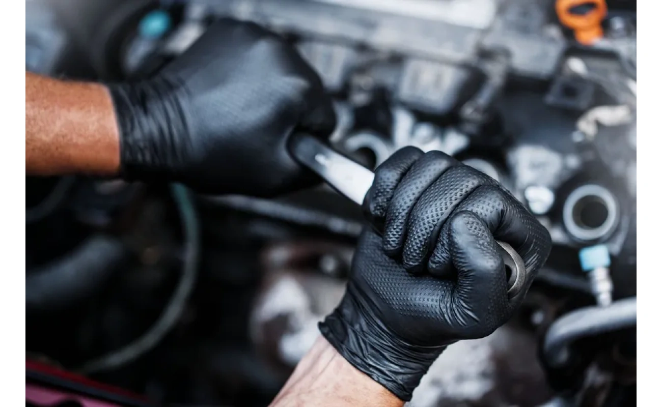 Bild vom GoGrip Nitrilhandschuh in schwarz bei der Arbeit an einem Auto